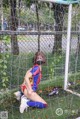 A woman wearing a face mask sitting in front of a soccer goal.