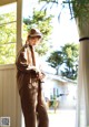 A woman standing in front of a window wearing a hat.