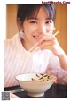 A young girl holding chopsticks over a bowl of soup.