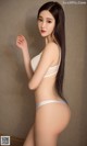 A woman in a white bra and panties posing for a picture.