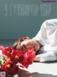A woman laying on the ground next to a bunch of flowers.