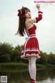 A woman in a red and white dress standing in the water.